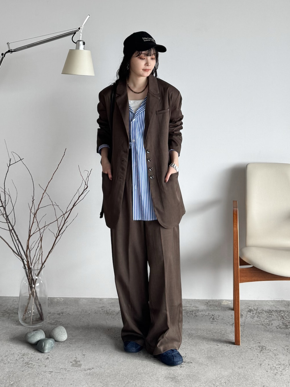 ブラウン系のテーラードジャケット、ブラウン系のスラックス、ブラック系のショルダーバッグを着用したレディースの秋コーディネートの2枚目の写真