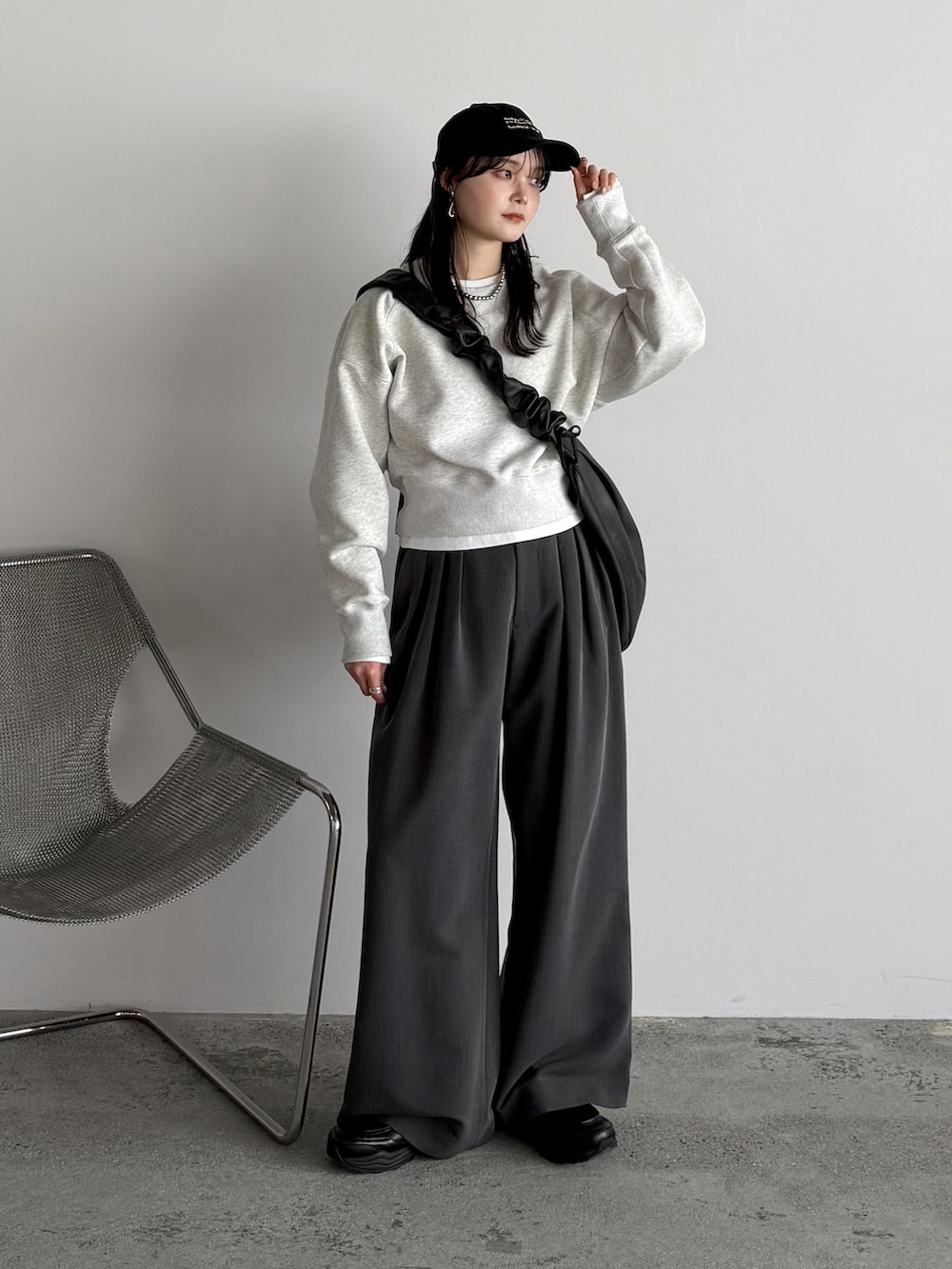 ブラック系のショルダーバッグ、グレー系のスウェット、ホワイト系のTシャツ/カットソーを着用したレディースの春コーディネートの2枚目の写真