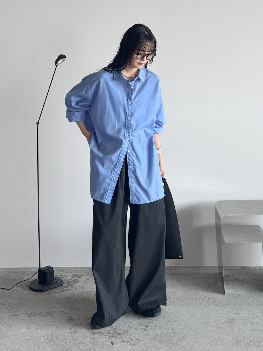 ブルー系のシャツ/ブラウス、ブラック系のモカシン/デッキシューズ、グレー系のスラックスを着用したレディースの秋コーディネートの2枚目の写真