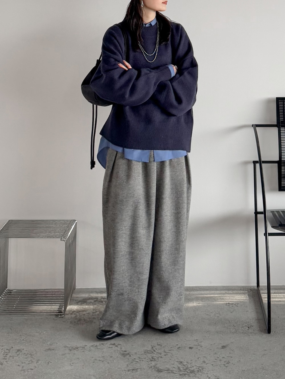 ブルー系のニット/セーター、ブルー系のシャツ/ブラウス、グレー系のスラックスを着用したレディースの秋コーディネートの2枚目の写真