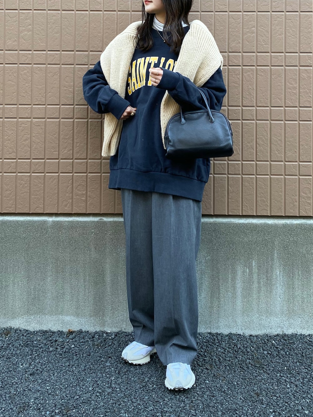 ブルー系のスウェット、ベージュ系のニット/セーター、グレー系のスラックスを着用したレディースの冬コーディネートの2枚目の写真