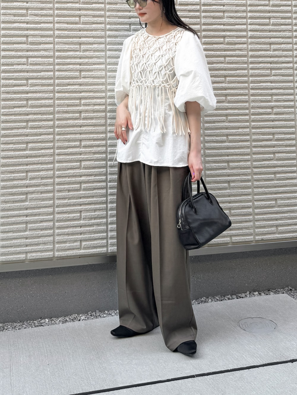 ホワイト系のシャツ/ブラウス、ホワイト系のベスト、ブラウン系のスラックスを着用したレディースの夏コーディネートの2枚目の写真
