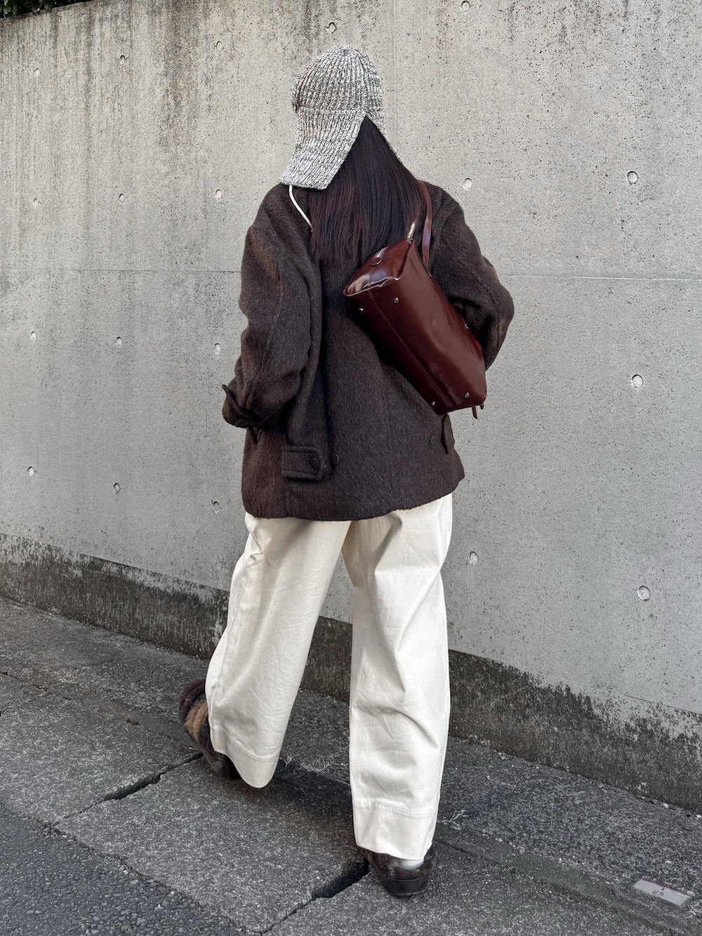 ブラウン系のブルゾン、ブラウン系のTシャツ/カットソー、ホワイト系のその他パンツを着用したレディースの冬コーディネートの3枚目の写真