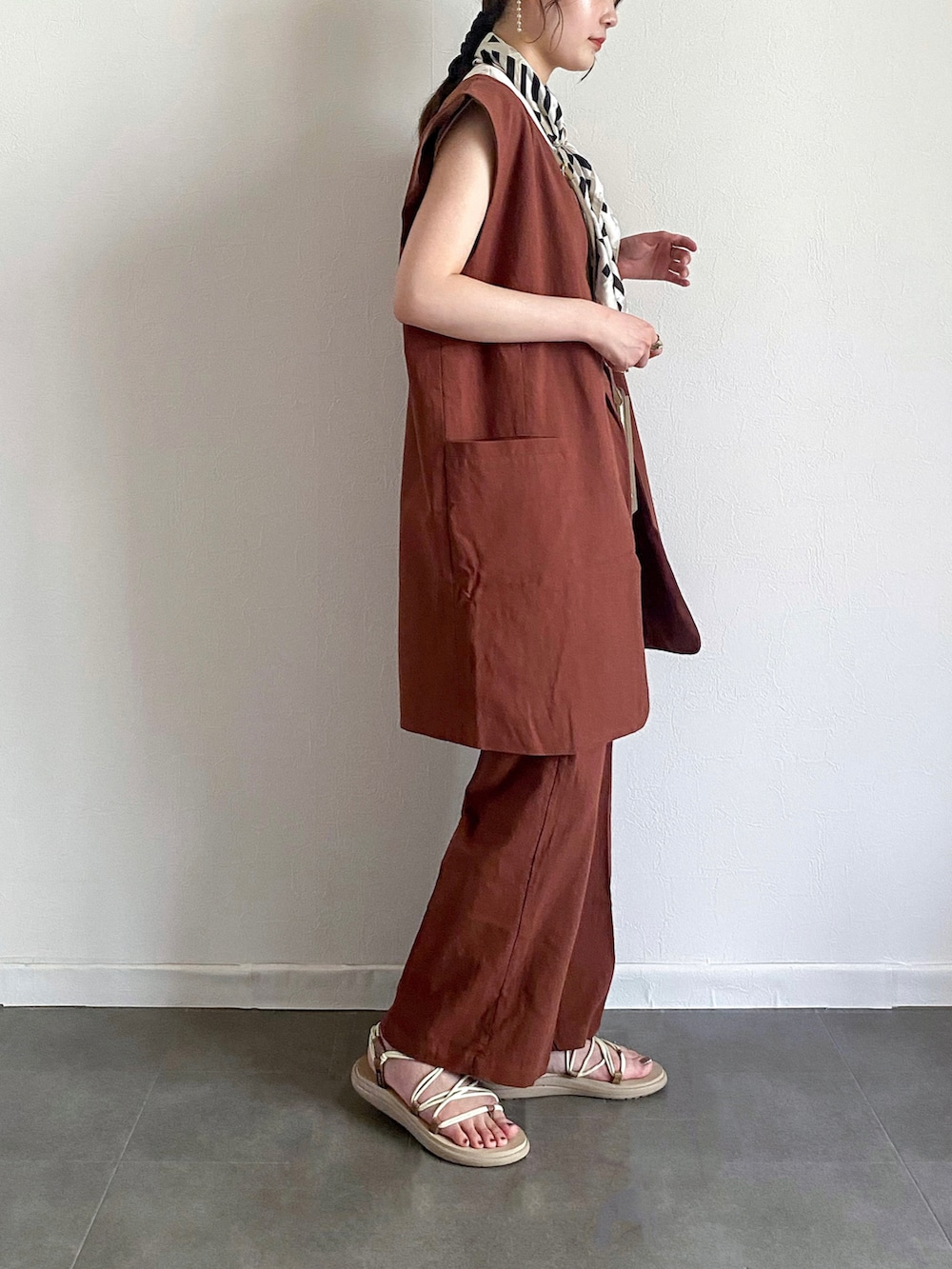 ブラウン系のベスト、ブラウン系のその他パンツ、ホワイト系のTシャツ/カットソーを着用したレディースの夏コーディネートの2枚目の写真