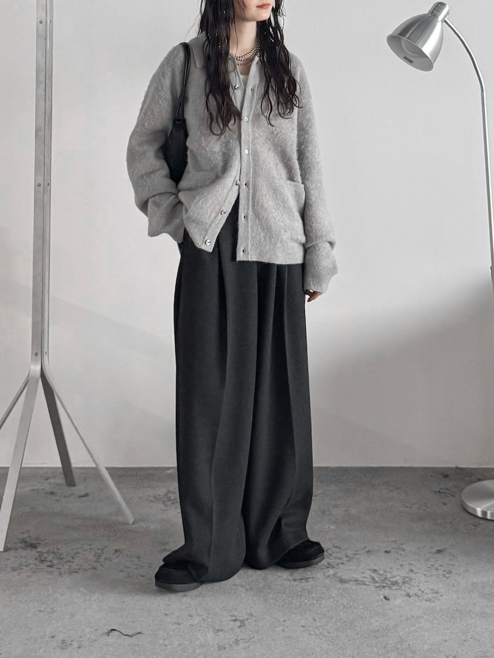 ブラック系のモカシン/デッキシューズ、グレー系のニット/セーター、グレー系のスラックスを着用したレディースの秋コーディネートの2枚目の写真