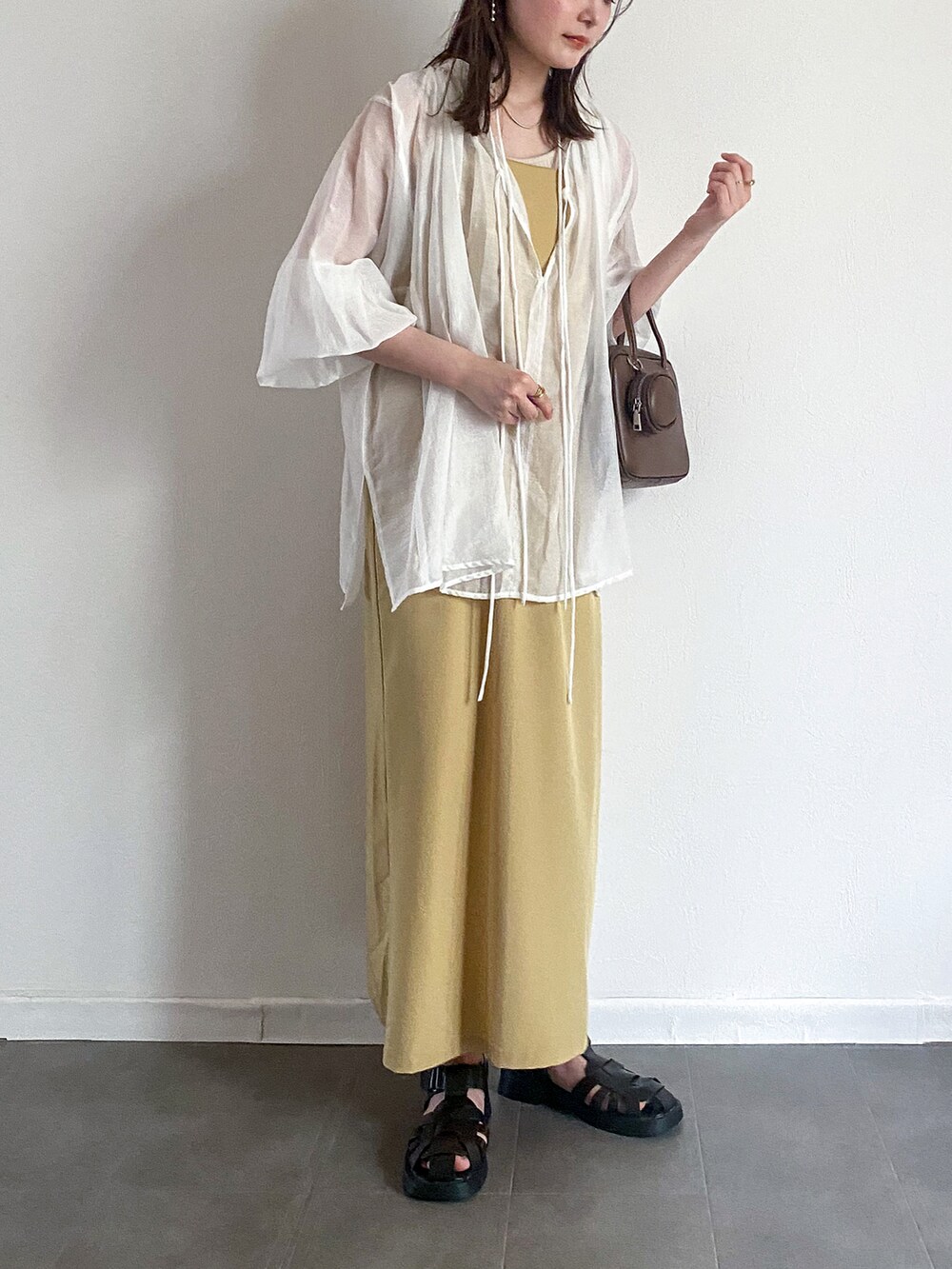 ホワイト系のシャツ/ブラウス、イエロー系のワンピース、ブラウン系のショルダーバッグを着用したレディースの夏コーディネートの2枚目の写真