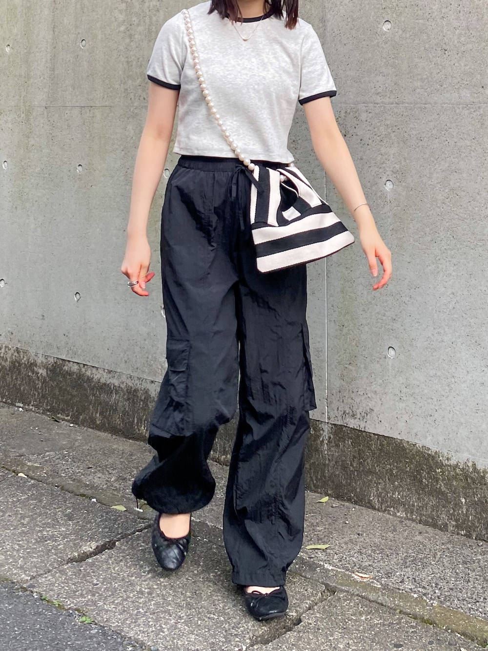 グレー系のTシャツ/カットソー、ホワイト系のショルダーバッグ、ブラック系のカーゴパンツを着用したレディースの夏コーディネートの2枚目の写真