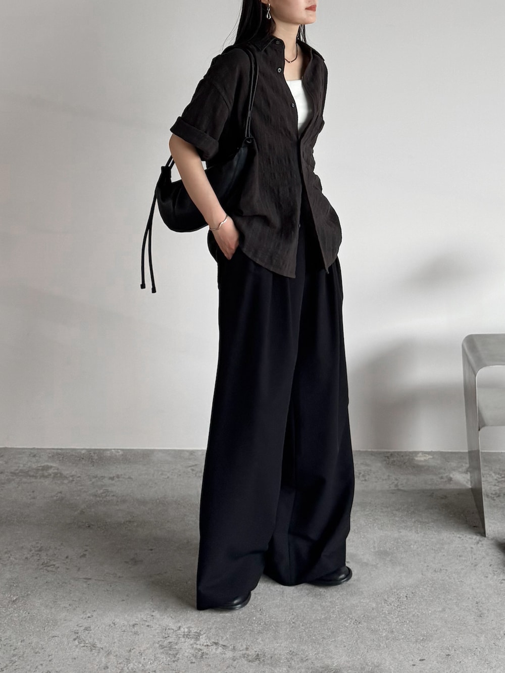 グレー系のシャツ/ブラウス、ブラック系のスラックス、ブラック系のショルダーバッグを着用したレディースの夏コーディネートの2枚目の写真