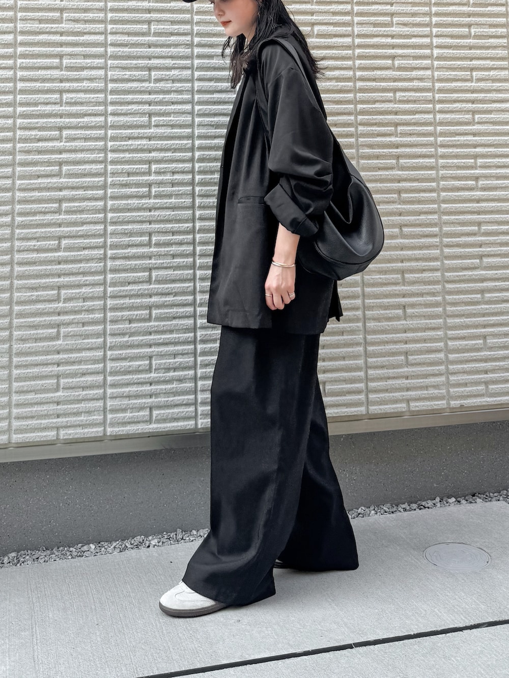 ブラック系のテーラードジャケット、ホワイト系のTシャツ/カットソー、ブラック系のスラックスを着用したレディースの秋コーディネートの2枚目の写真