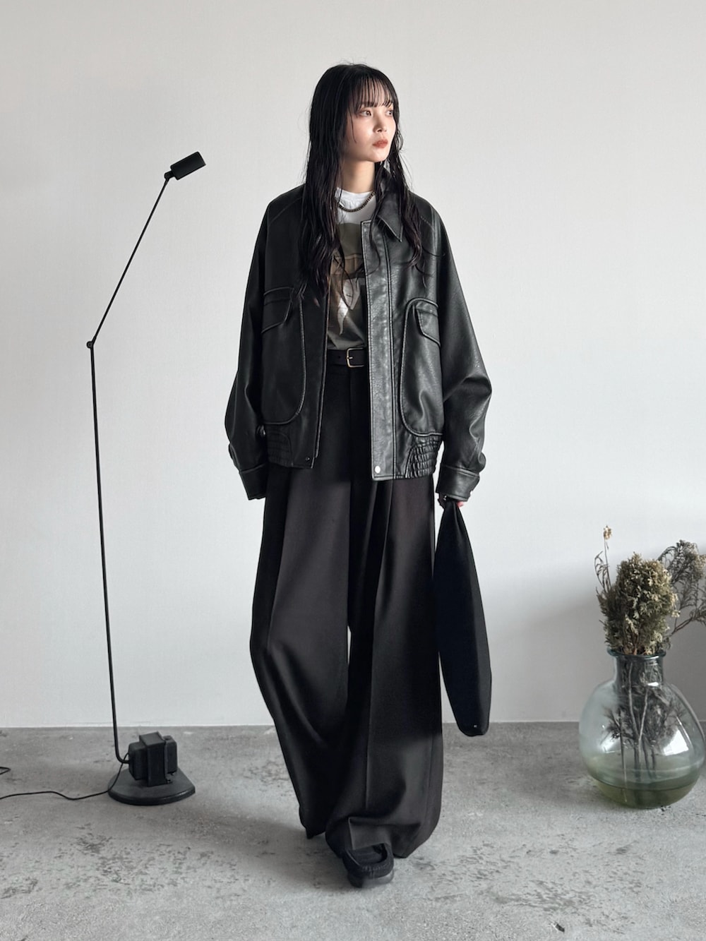 ホワイト系のTシャツ/カットソー、グレー系のブルゾン、ブラウン系のスラックスを着用したレディースの秋コーディネートの2枚目の写真