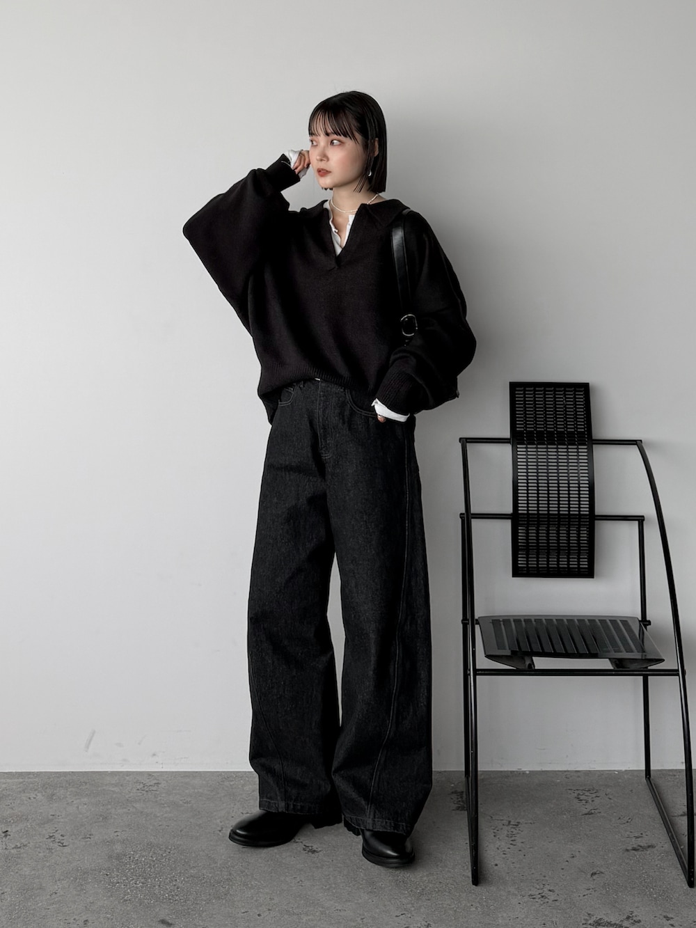 ブラック系のニット/セーター、ホワイト系のカーディガン/ボレロ、ブラック系のデニムパンツを着用したレディースの秋コーディネートの2枚目の写真