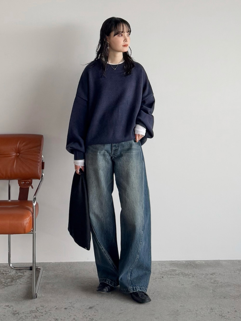 ブルー系のニット/セーター、ホワイト系のTシャツ/カットソー、ブルー系のデニムパンツを着用したレディースの秋コーディネートの2枚目の写真