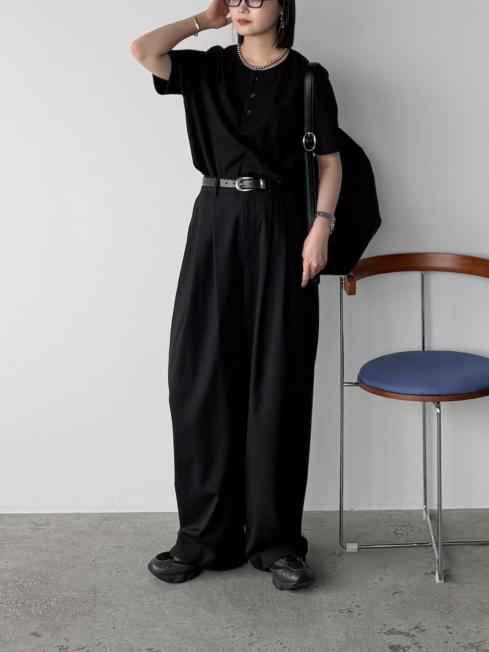ブラック系のTシャツ/カットソー、ブラック系のスラックス、ブラック系のショルダーバッグを着用したレディースの夏コーディネートの2枚目の写真