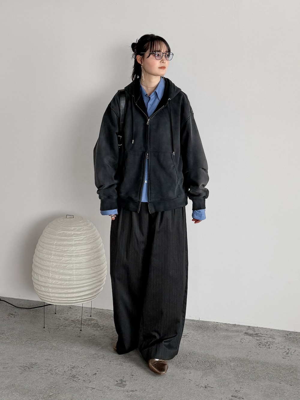 ブラック系のパーカー、ブルー系のシャツ/ブラウス、グレー系のスラックスを着用したレディースの春コーディネートの2枚目の写真