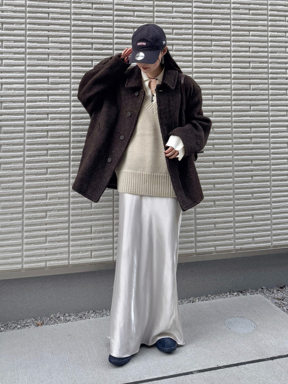 ブラウン系のブルゾン、ホワイト系のベスト、ホワイト系のニット/セーターを着用したレディースの冬コーディネートの3枚目の写真