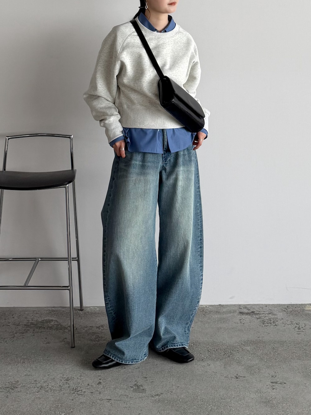 ブラック系のショルダーバッグ、ブルー系のシャツ/ブラウス、ブルー系のデニムパンツを着用したレディースの春コーディネートの2枚目の写真