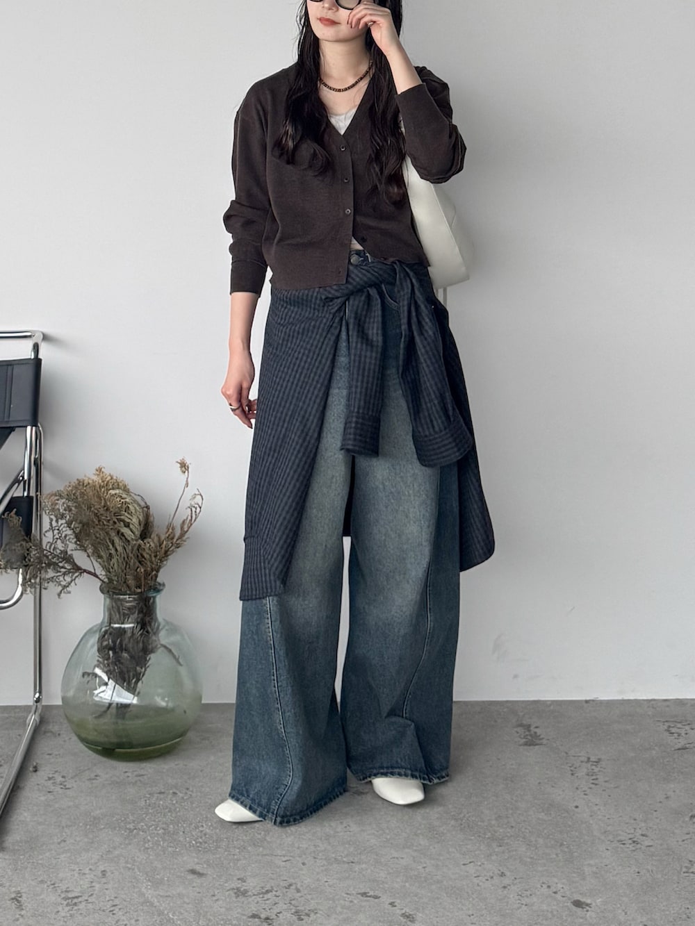 ブルー系のデニムパンツ、ブラウン系のニット/セーター、ブルー系のシャツ/ブラウスを着用したレディースの秋コーディネートの2枚目の写真