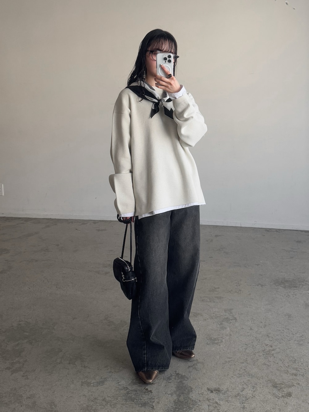 ホワイト系のニット/セーター、ブラック系のデニムパンツ、ゴールド系のパンプスを着用したレディースの冬コーディネートの3枚目の写真