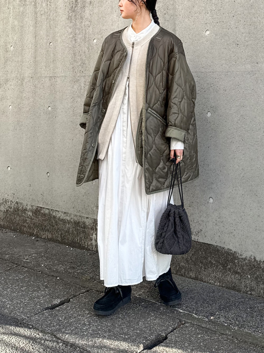 グリーン系のノーカラージャケット、ベージュ系のベスト、ホワイト系のシャツワンピースを着用したレディースの冬コーディネートの2枚目の写真