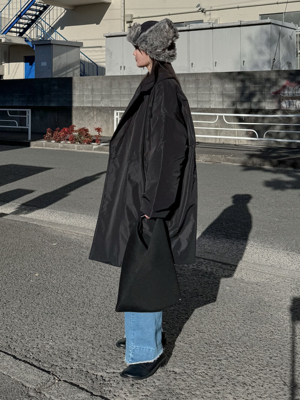 ブラック系のその他アウター、ベージュ系のニット/セーター、ブルー系のデニムパンツを着用したレディースの冬コーディネートの2枚目の写真