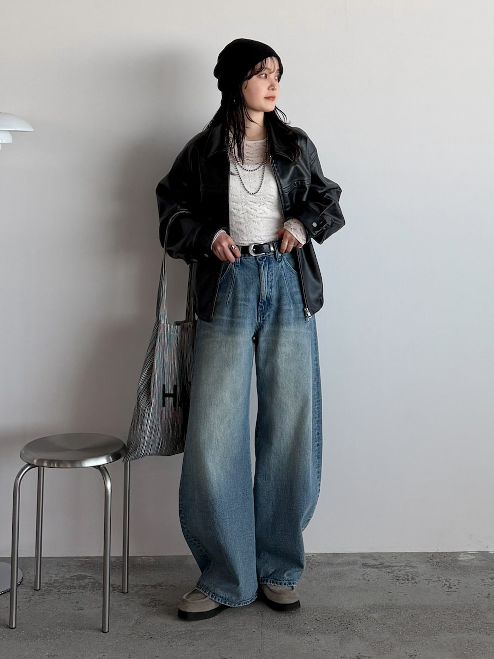 ブラック系のブルゾン、ブルー系のデニムパンツ、ホワイト系のTシャツ/カットソーを着用したレディースの冬コーディネートの2枚目の写真