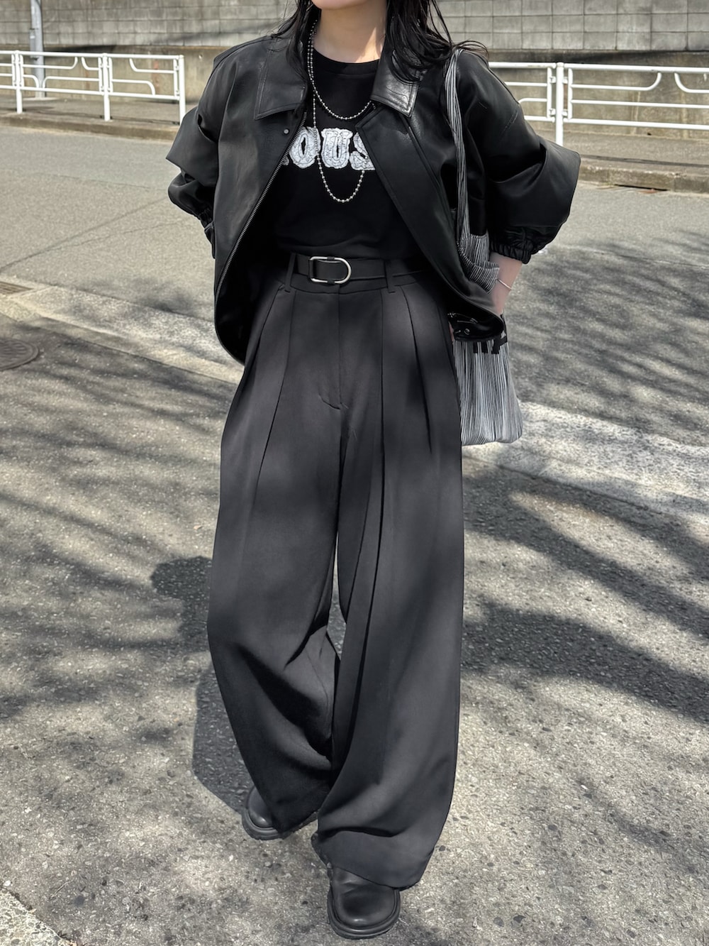 ブラック系のブルゾン、ブラック系のTシャツ/カットソー、ブラック系のその他パンツを着用したレディースの春コーディネートの2枚目の写真