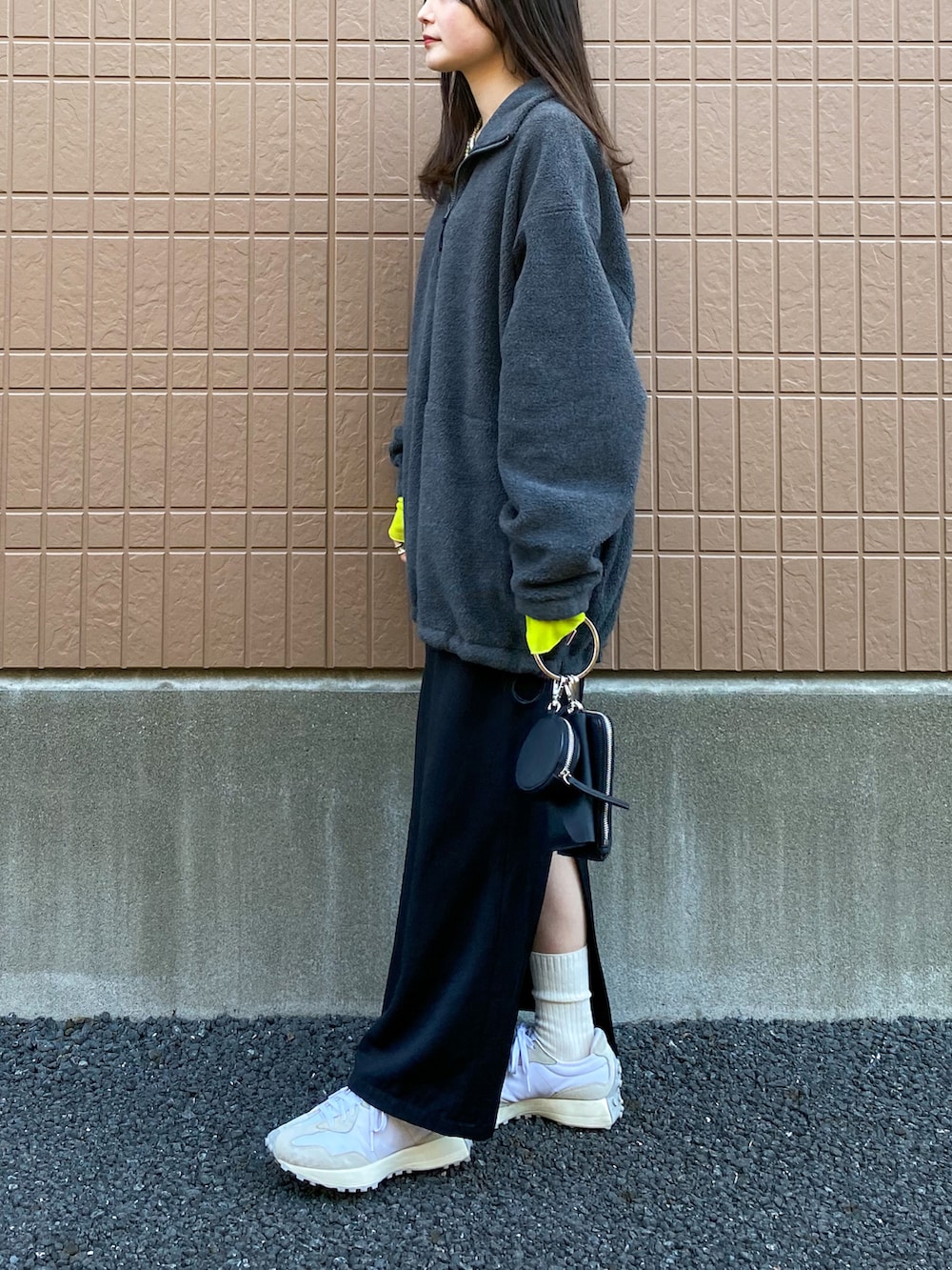 グレー系のスウェット、グリーン系のTシャツ/カットソー、ブラック系のショルダーバッグを着用したレディースの冬コーディネートの2枚目の写真