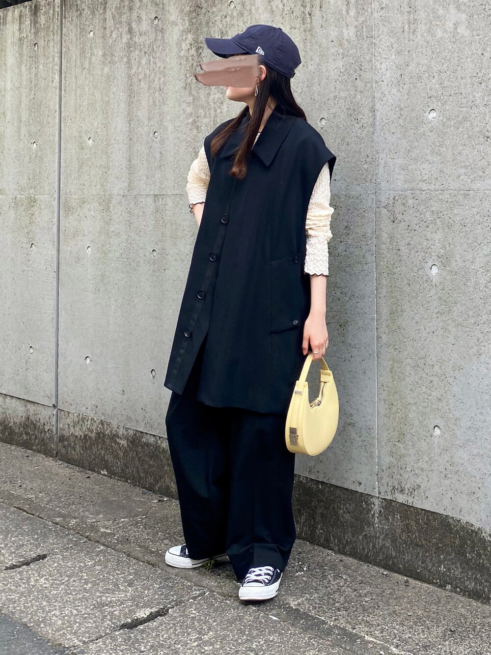 ホワイト系のTシャツ/カットソー、ブラック系のベスト、ブラック系のスラックスを着用したレディースの春コーディネートの2枚目の写真