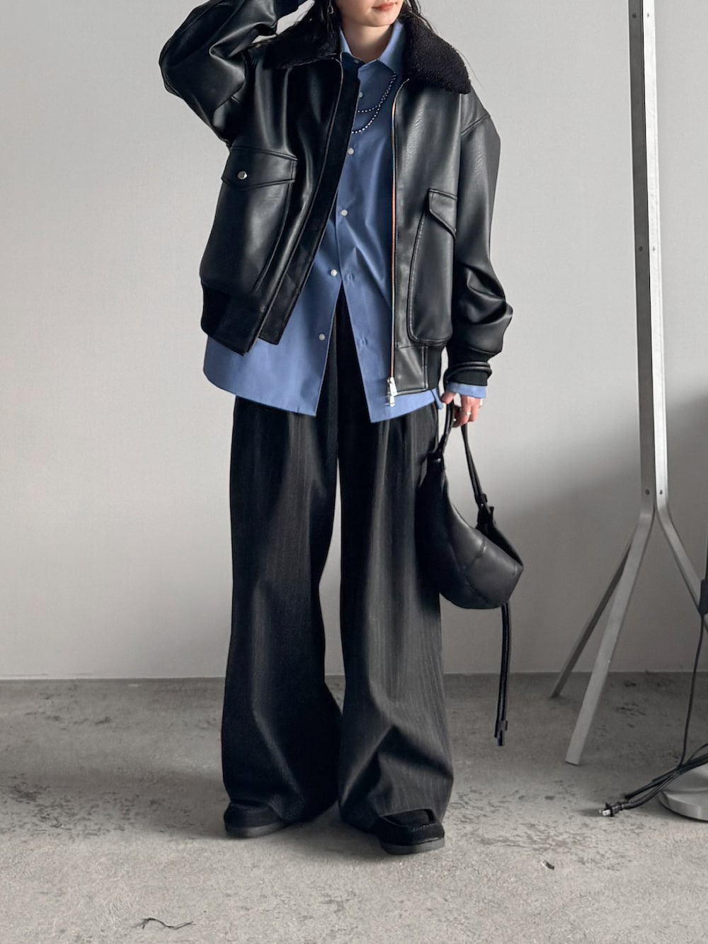 ブルー系のシャツ/ブラウス、ブラック系のブルゾン、グレー系のスラックスを着用したレディースの秋コーディネートの2枚目の写真