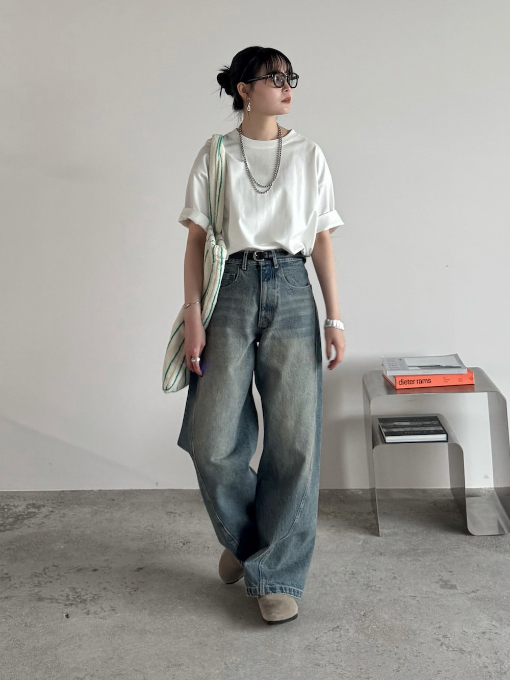 ホワイト系のTシャツ/カットソー、ブルー系のデニムパンツ、ホワイト系のトートバッグを着用したレディースの夏コーディネートの2枚目の写真