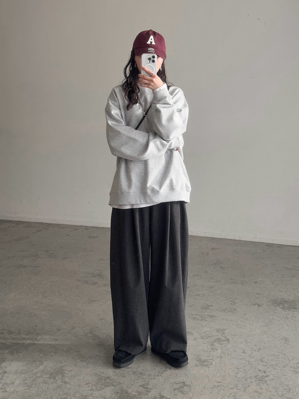 グレー系のスウェット、ホワイト系のTシャツ/カットソー、グレー系のスラックスを着用したレディースの冬コーディネートの2枚目の写真