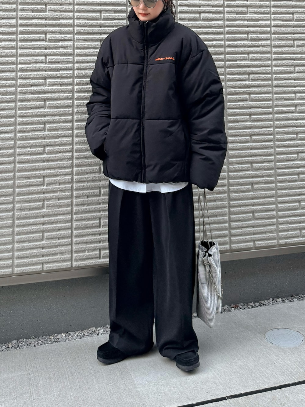 ブラック系のダウンジャケット/コート、ブラック系のその他パンツ、シルバー系のショルダーバッグを着用したレディースの秋コーディネートの2枚目の写真