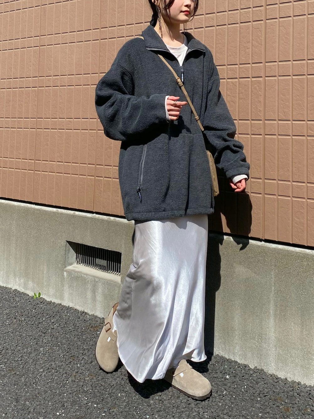 グレー系のスウェット、ホワイト系のスカート、ベージュ系のショルダーバッグを着用したレディースの春コーディネートの2枚目の写真