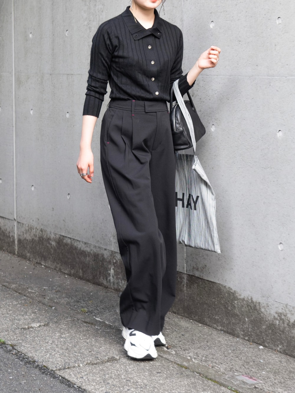 ブラック系のニット/セーター、ブラック系のその他パンツ、ブラック系のショルダーバッグを着用したレディースの秋コーディネートの4枚目の写真