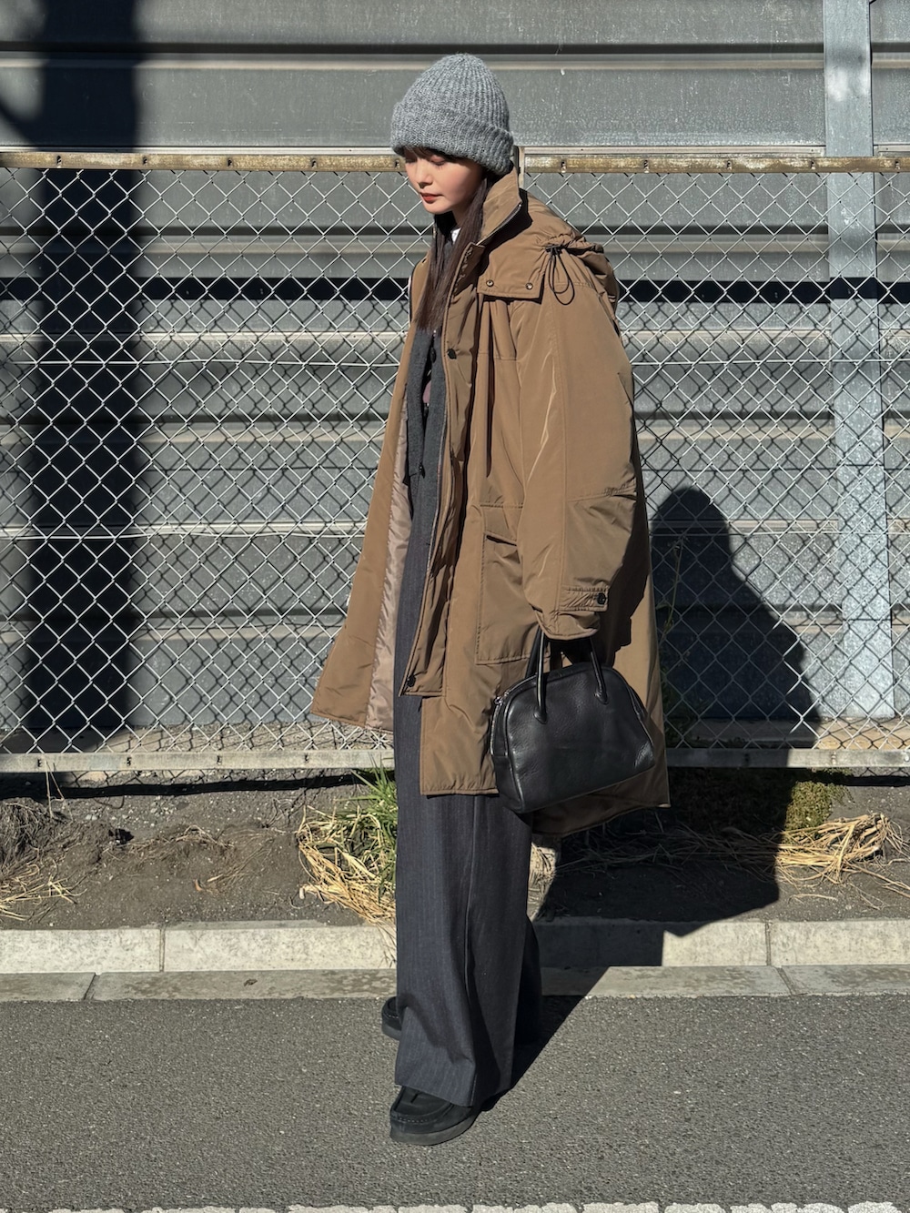 ベージュ系のダウンジャケット/コート、グレー系のカーディガン/ボレロ、ホワイト系のTシャツ/カットソーを着用したレディースの冬コーディネートの2枚目の写真