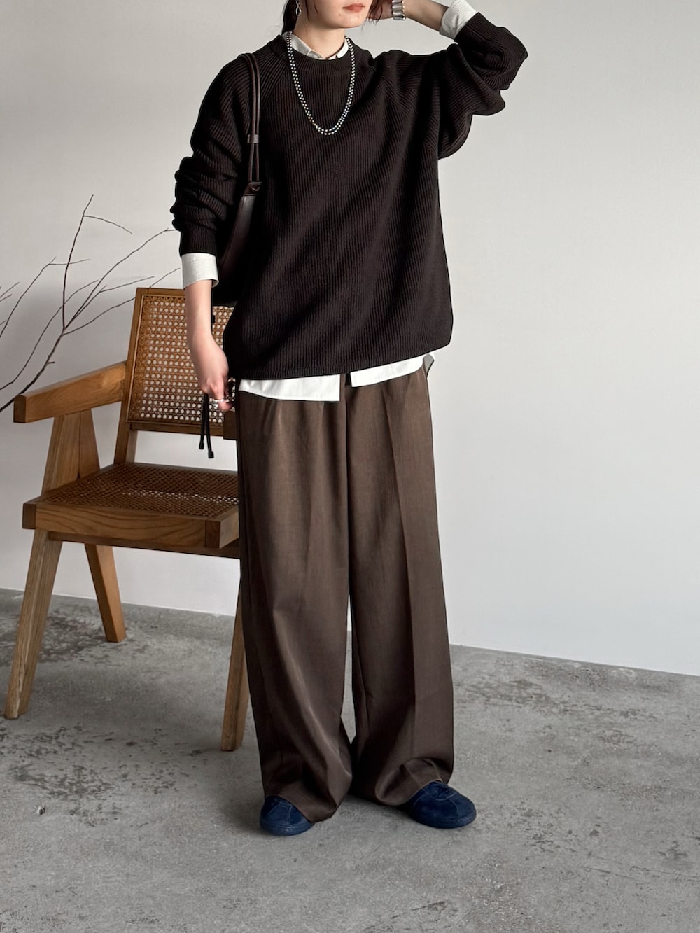 ブラウン系のニット/セーター、ブラウン系のスラックス、ブラウン系のショルダーバッグを着用したレディースの秋コーディネートの2枚目の写真