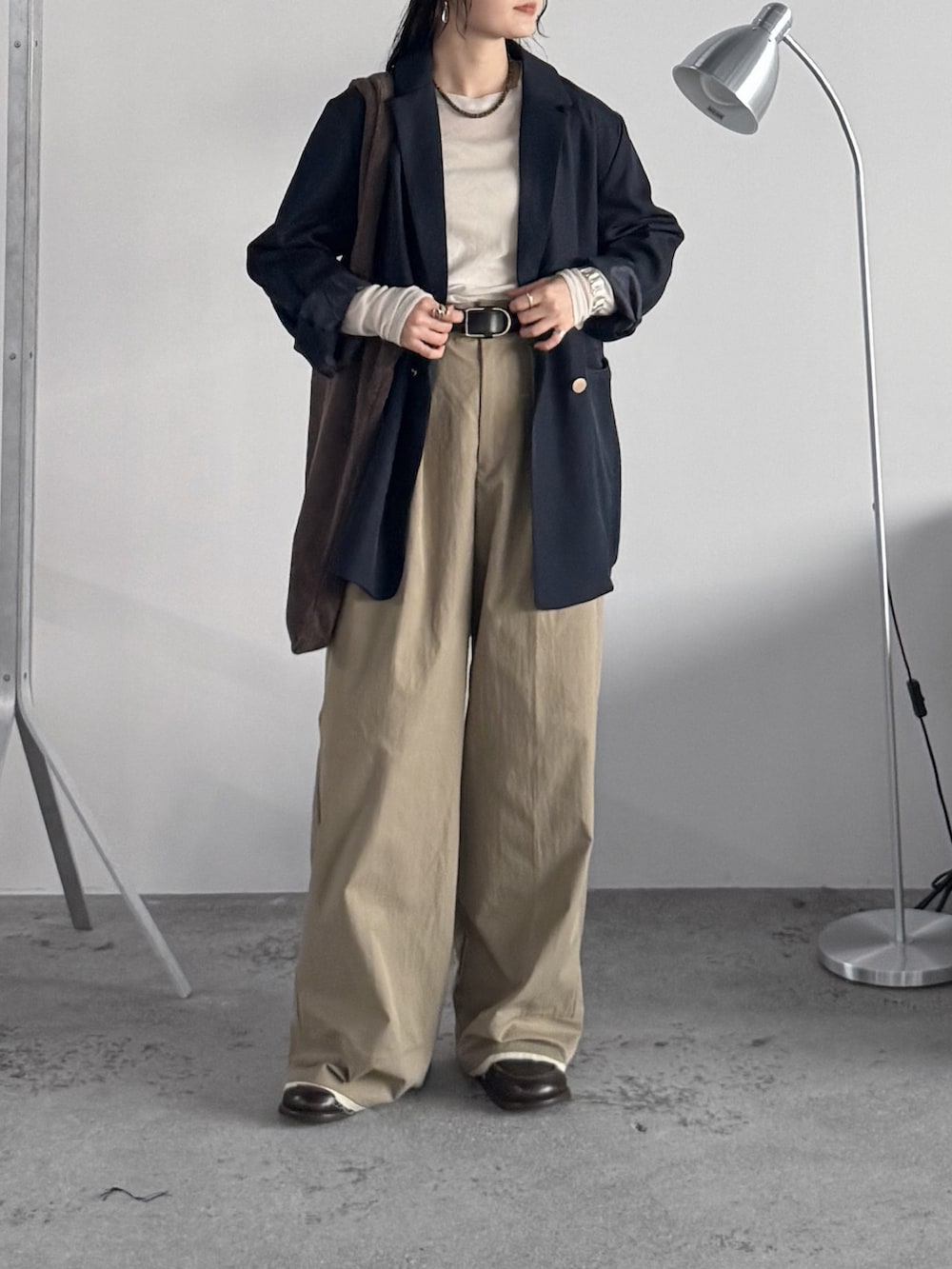 ブルー系のテーラードジャケット、ホワイト系のTシャツ/カットソー、ベージュ系のスラックスを着用したレディースの秋コーディネートの2枚目の写真