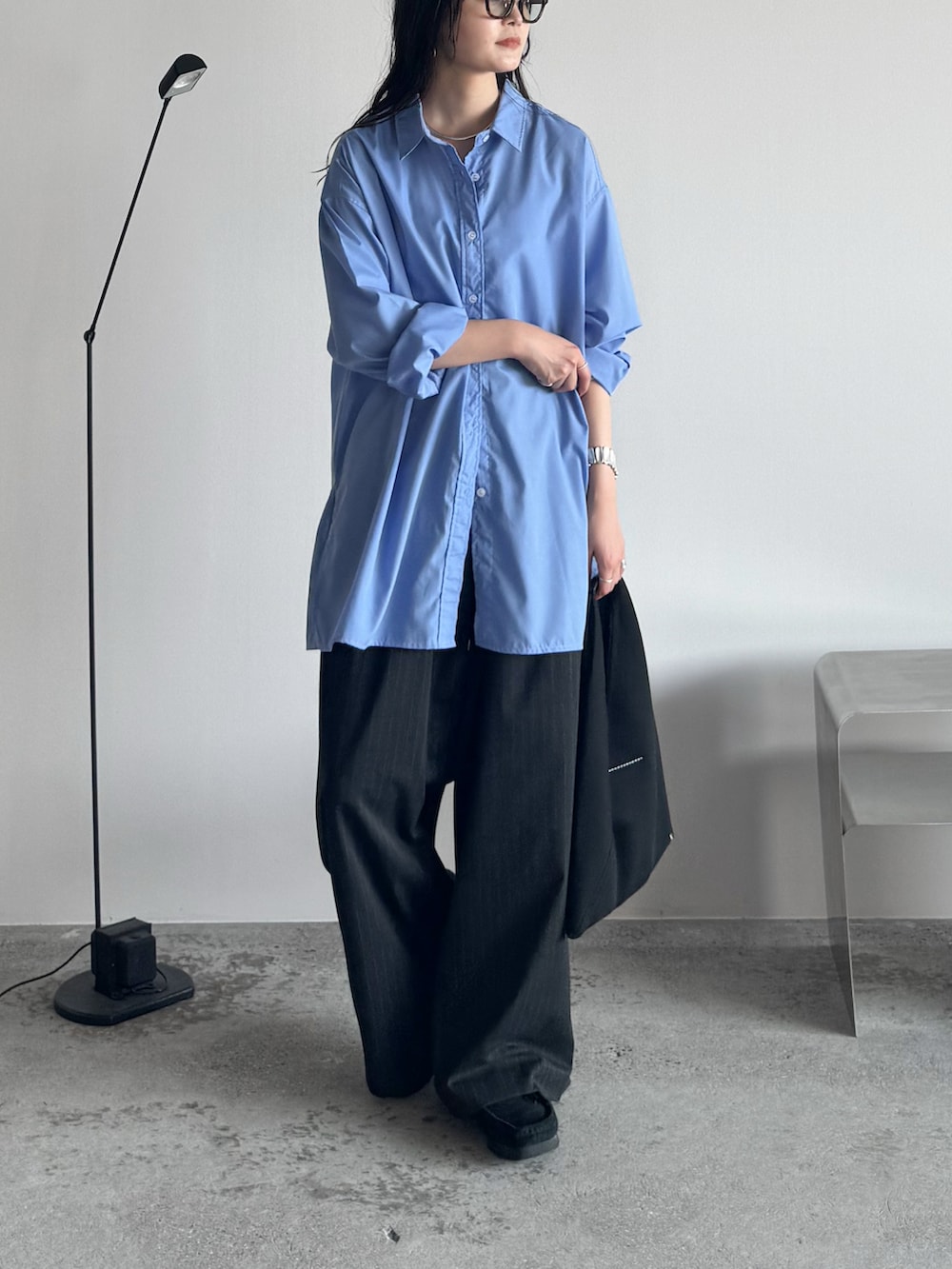 ブルー系のシャツ/ブラウス、ブラック系のモカシン/デッキシューズ、グレー系のスラックスを着用したレディースの秋コーディネートの3枚目の写真