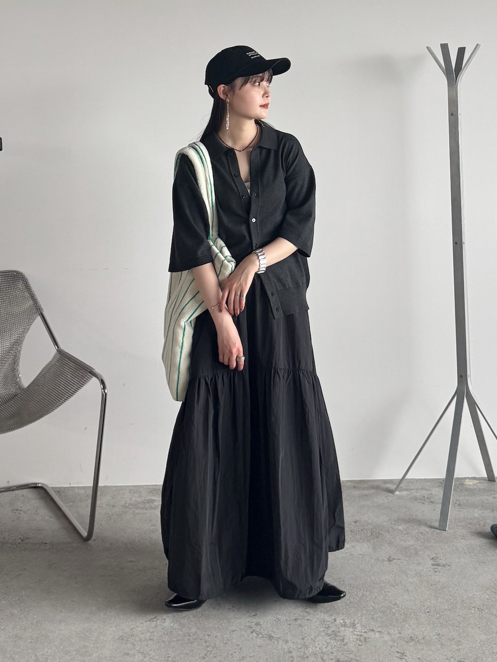 グレー系のシャツ/ブラウス、ブラック系のスカート、ホワイト系のトートバッグを着用したレディースの夏コーディネートの2枚目の写真