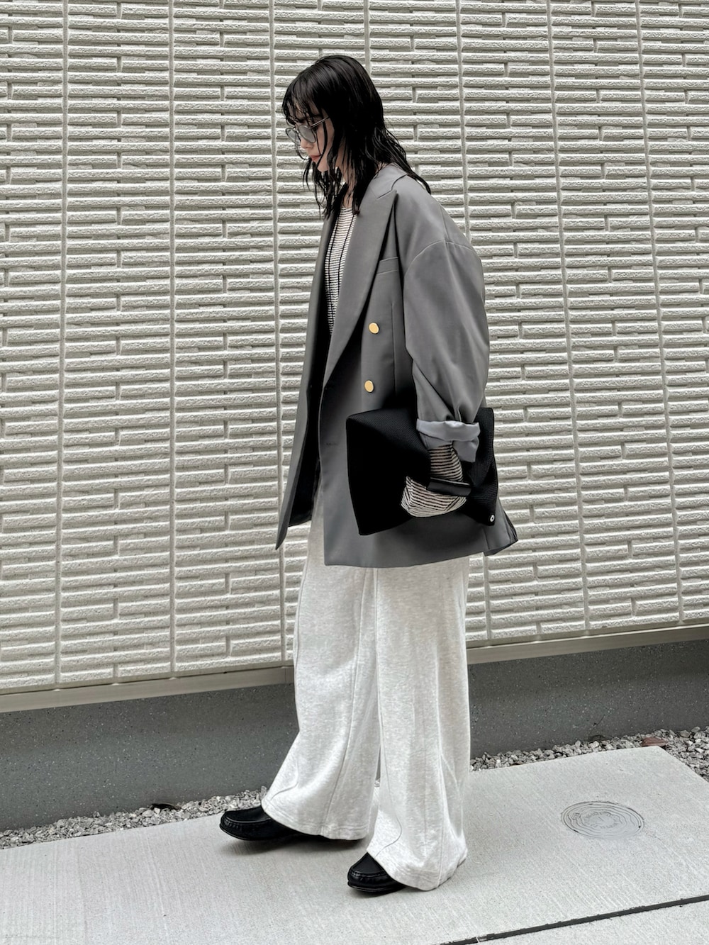 グレー系のテーラードジャケット、ホワイト系のTシャツ/カットソー、グレー系のスウェットパンツを着用したレディースの春コーディネートの2枚目の写真