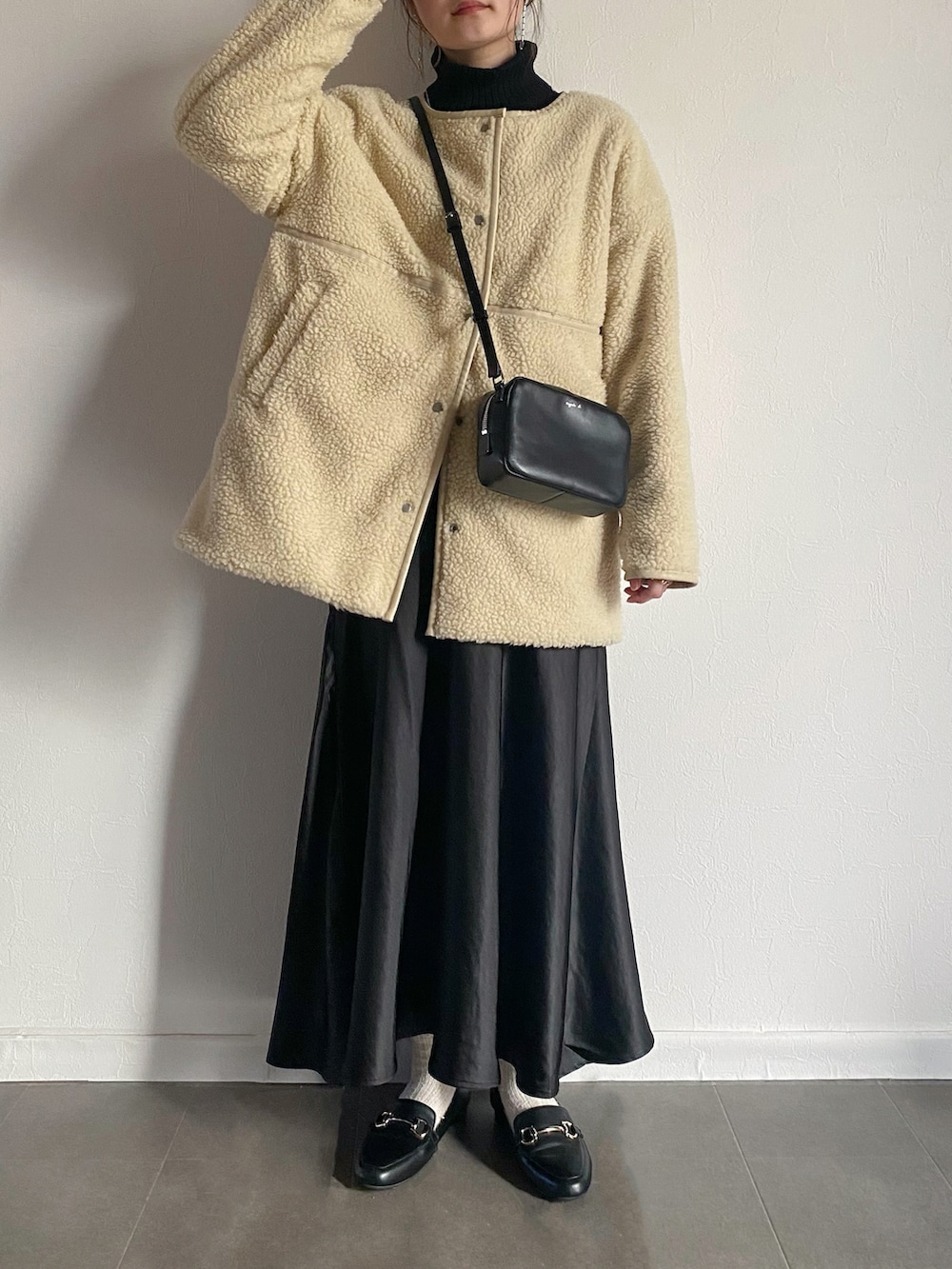 ホワイト系のダウンジャケット/コート、ブラック系のスカート、ブラック系のローファーを着用したレディースの冬コーディネートの2枚目の写真