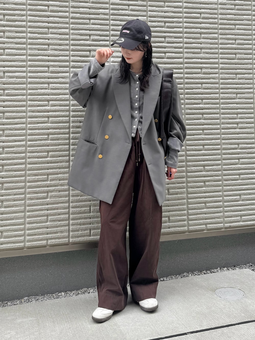 グレー系のテーラードジャケット、グレー系のカーディガン/ボレロ、レッド系のチノパンツを着用したレディースの秋コーディネートの2枚目の写真