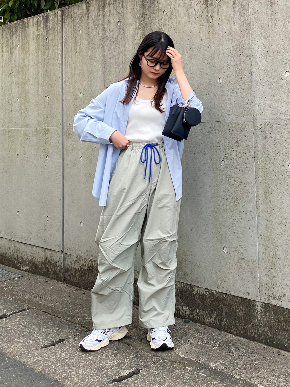 グレー系のその他パンツ、ブルー系のシャツ/ブラウス、ホワイト系のタンクトップを着用したレディースの春コーディネートの2枚目の写真