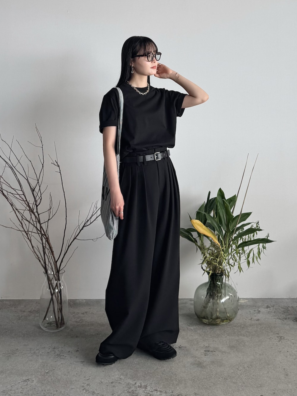 ブラック系のTシャツ/カットソー、ブラック系のスラックス、シルバー系のネックレスを着用したレディースの夏コーディネートの2枚目の写真