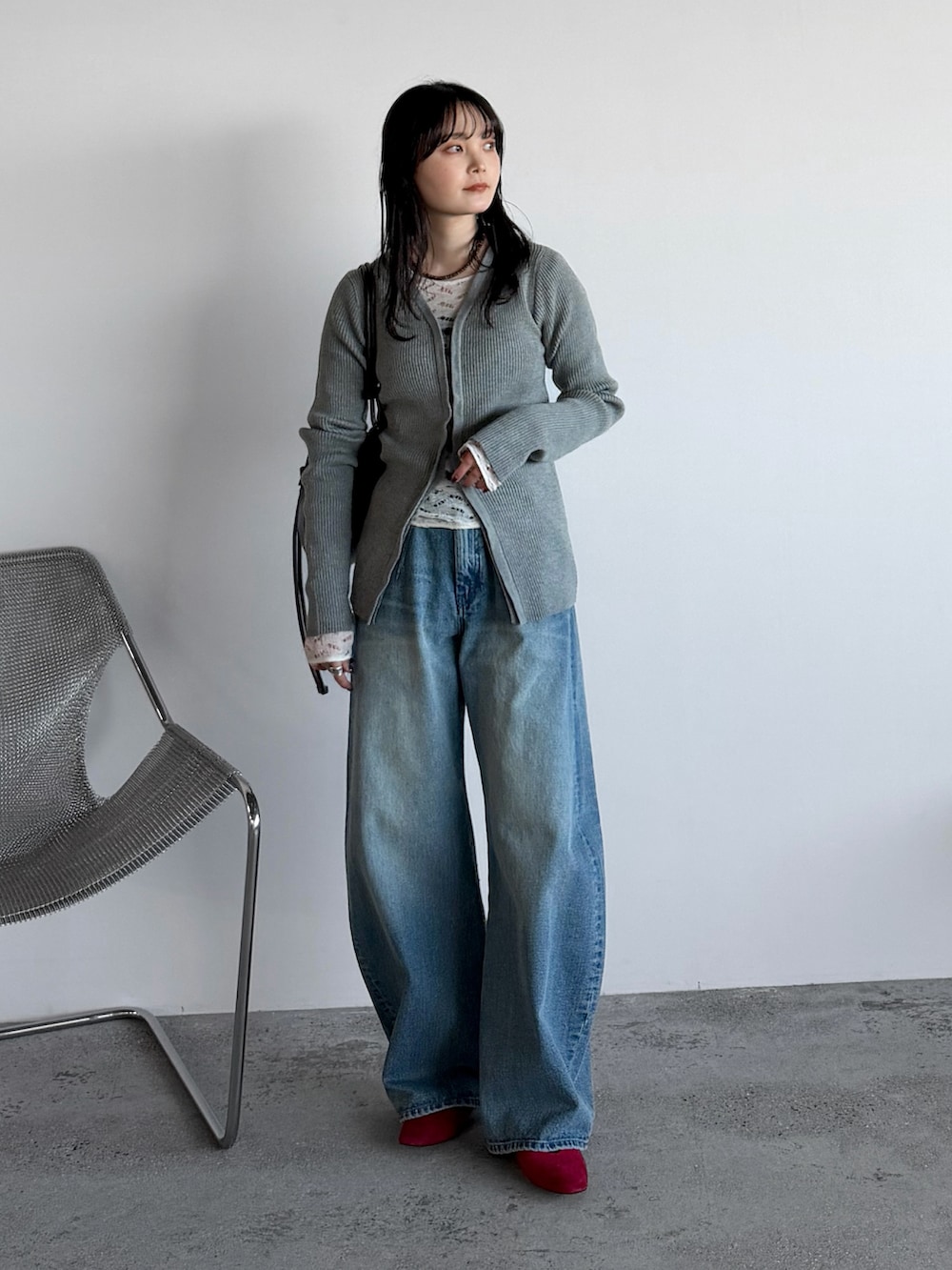 グレー系のカーディガン/ボレロ、ブルー系のデニムパンツ、ブラウン系のショルダーバッグを着用したレディースの春コーディネートの2枚目の写真