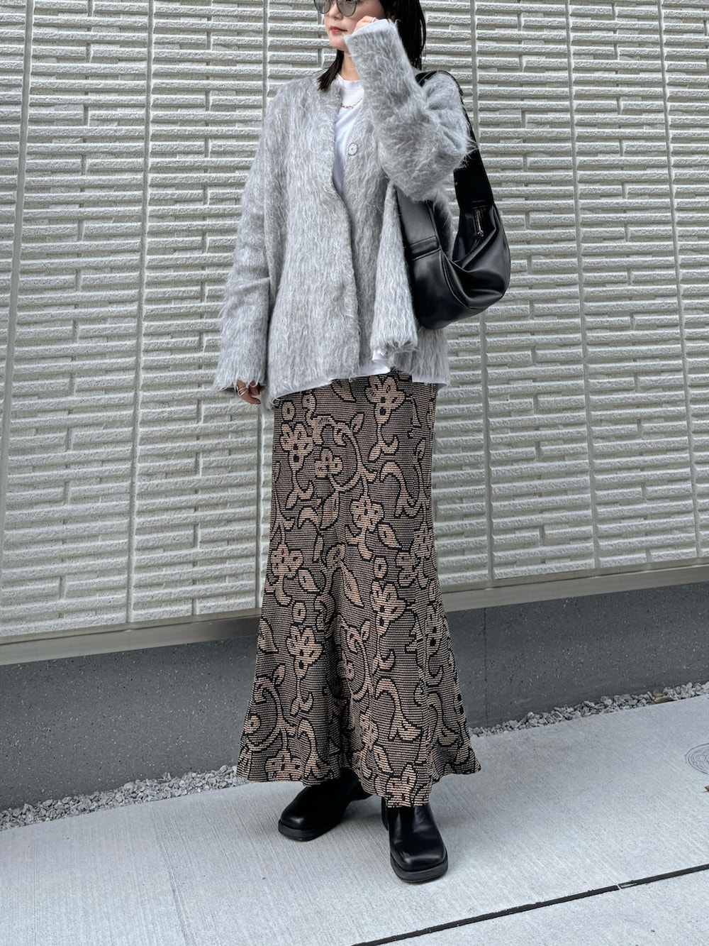 グレー系のカーディガン/ボレロ、ホワイト系のTシャツ/カットソー、ブラック系のスカートを着用したレディースの冬コーディネートの2枚目の写真