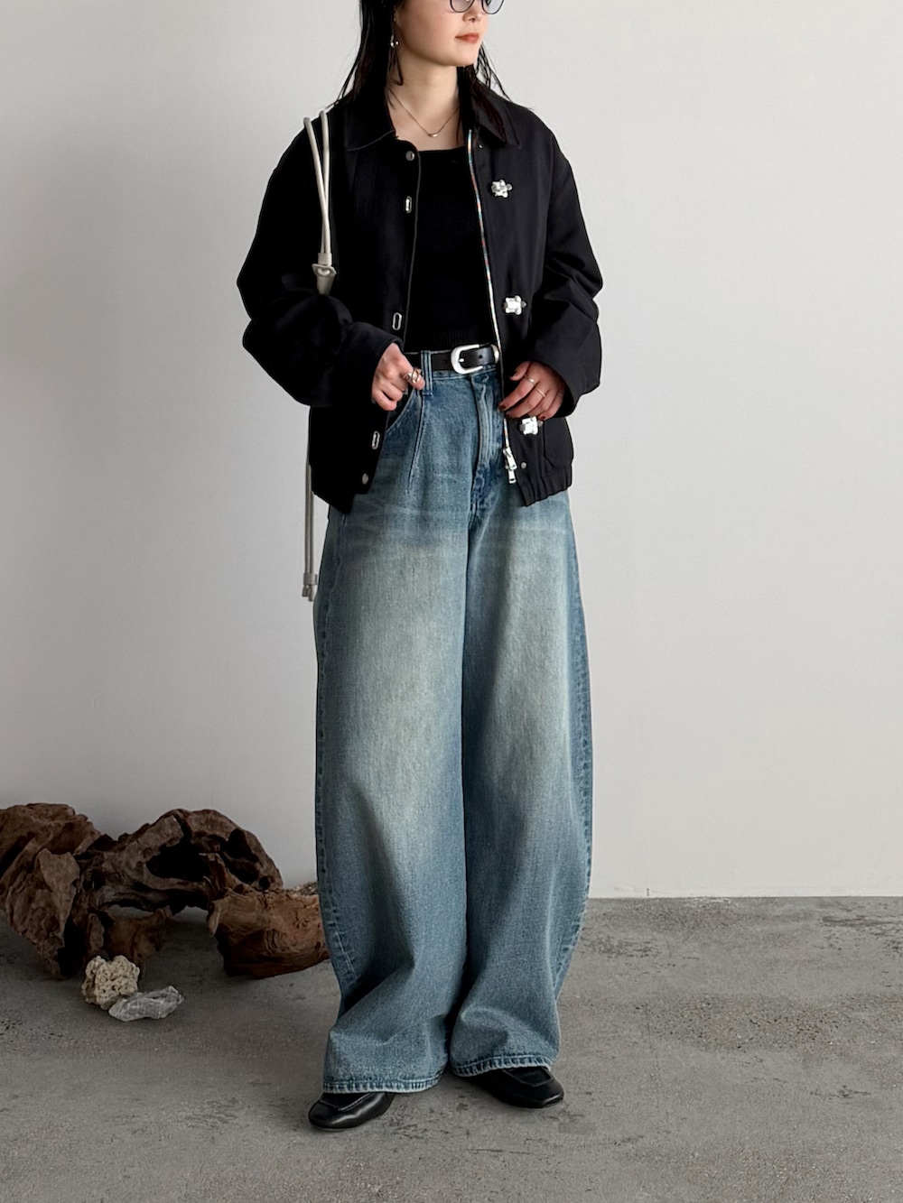 ブラック系のニット/セーター、ブラック系のブルゾン、ブルー系のデニムパンツを着用したレディースの冬コーディネートの2枚目の写真