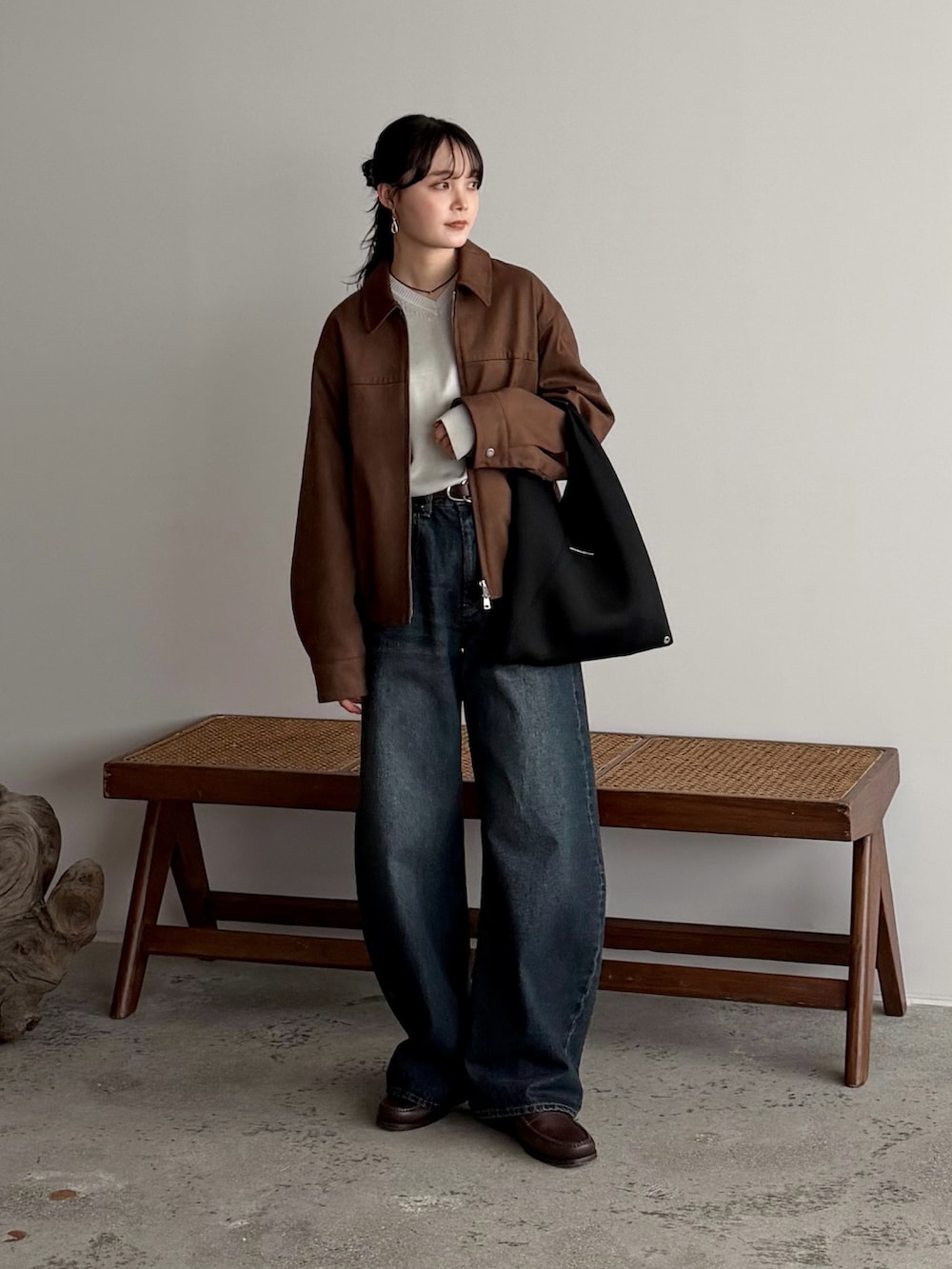 ホワイト系のニット/セーター、ブラウン系のブルゾン、ブルー系のデニムパンツを着用したレディースの冬コーディネートの2枚目の写真