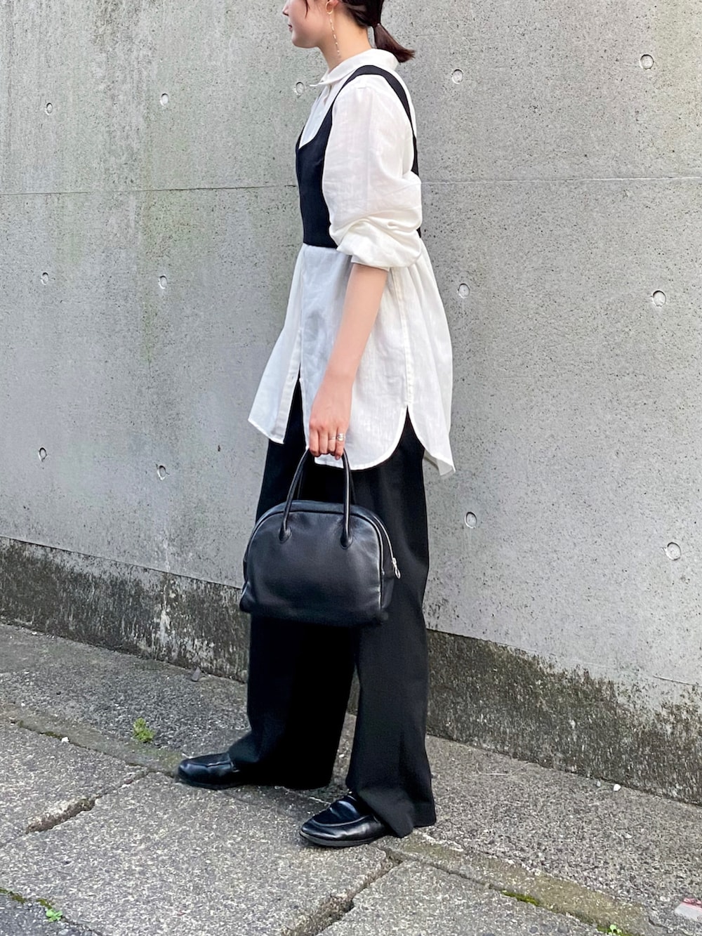 ホワイト系のシャツ/ブラウス、ブラック系のその他トップス、ブラック系のスラックスを着用したレディースの夏コーディネートの2枚目の写真