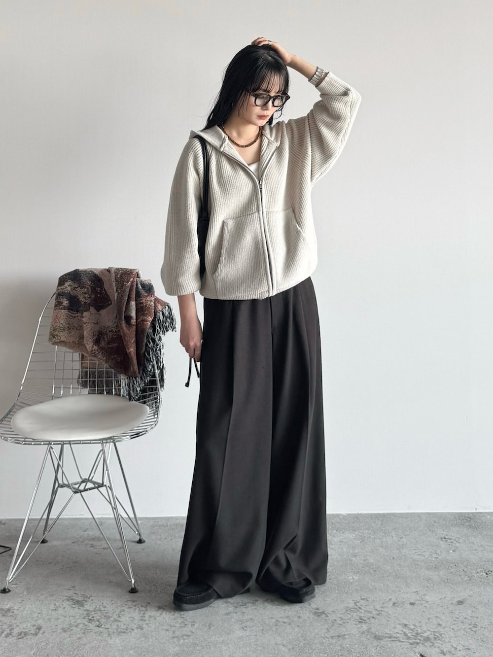 ブラック系のモカシン/デッキシューズ、ホワイト系のニット/セーター、ブラウン系のスラックスを着用したレディースの秋コーディネートの2枚目の写真